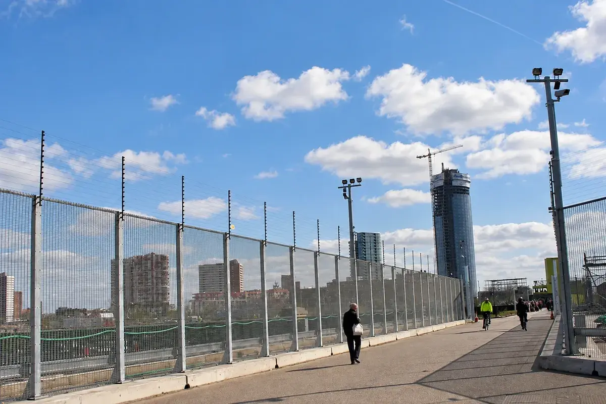 Long installed mesh security fence along an urban walkway