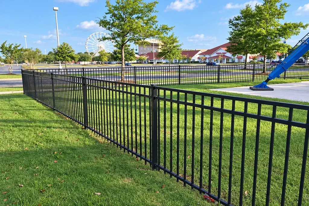 Black coated steel fence along a landscaped public area