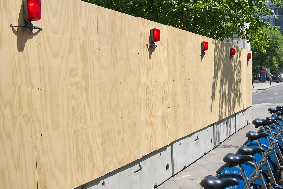 Solid timber hoarding along a city pavement