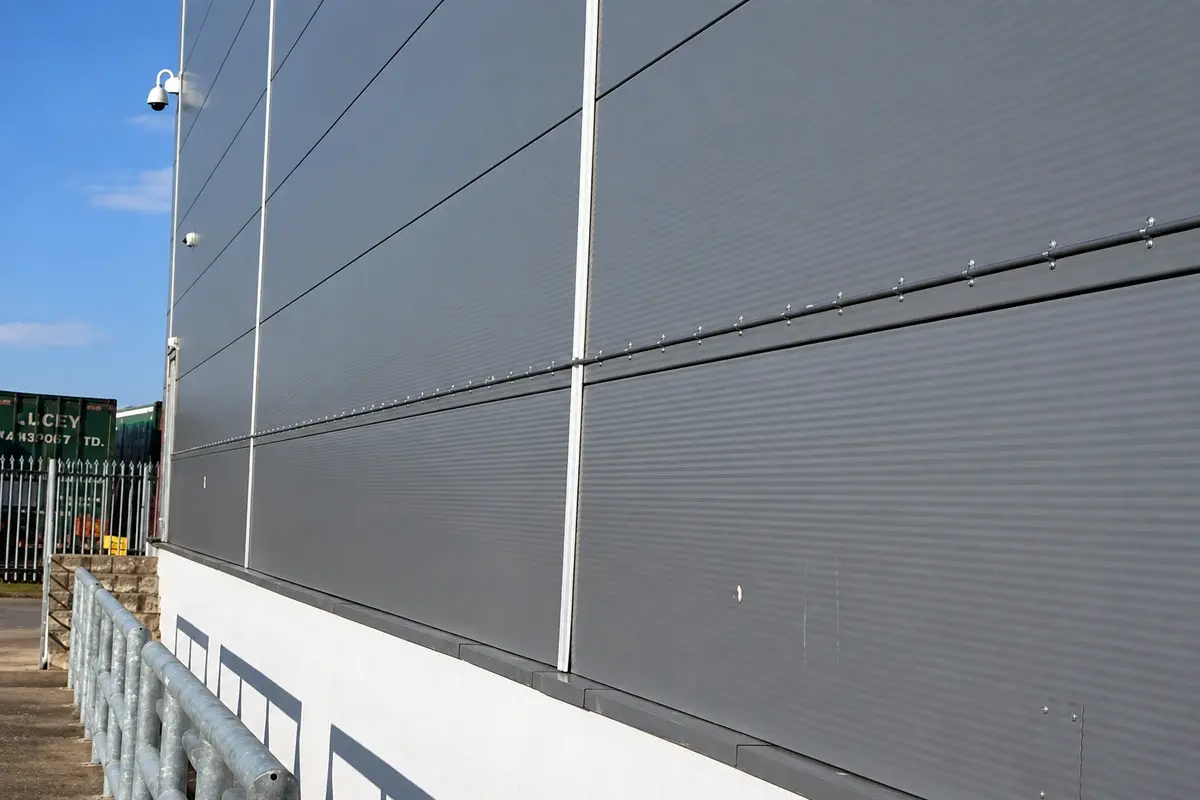 Horizontal cables attached to a grey panelled wall