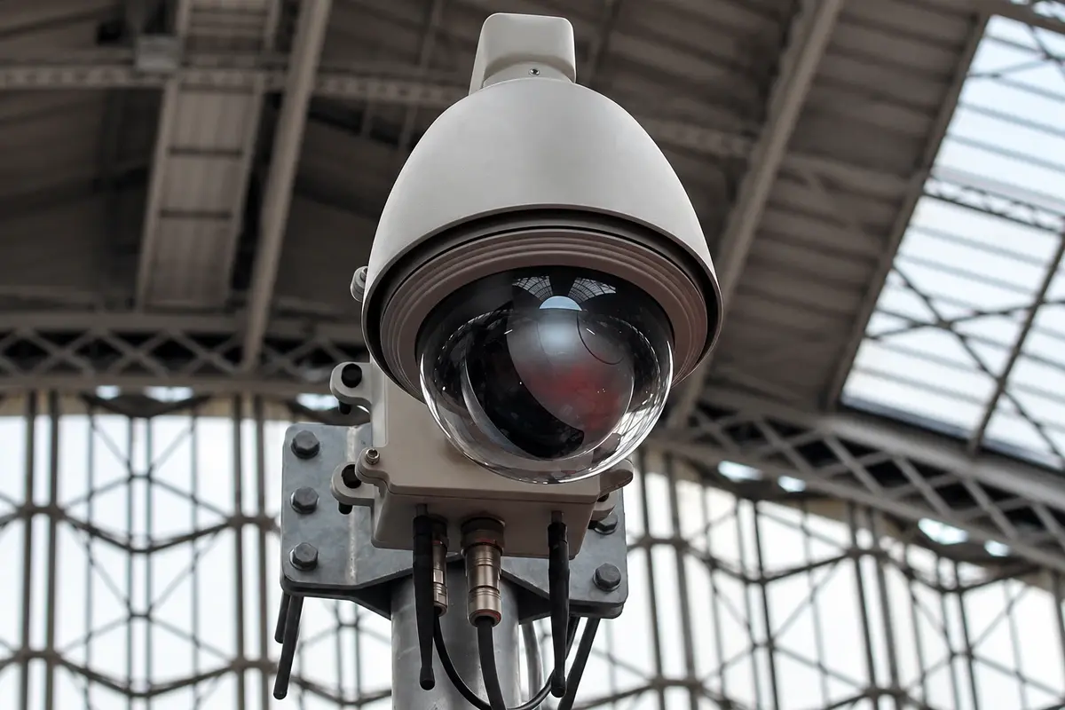 Close view of a dome camera with its mounting bracket and cables
