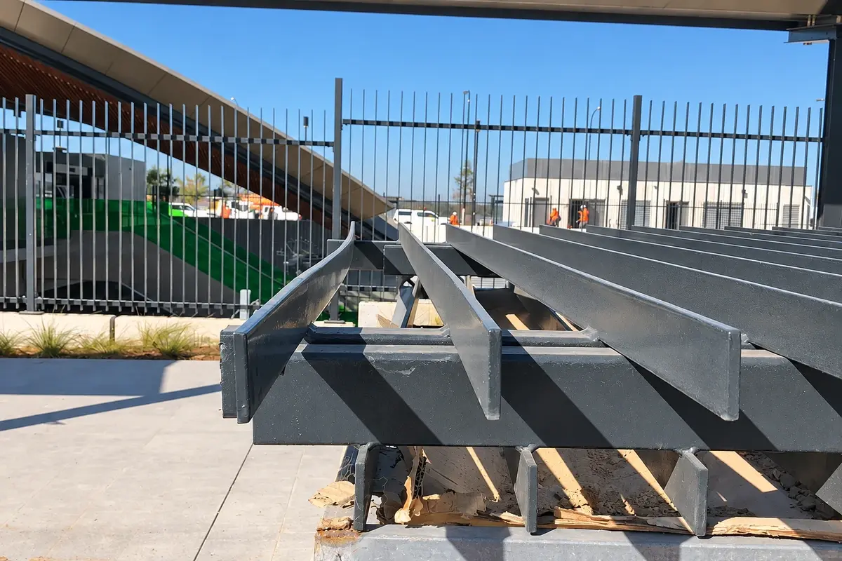 Metal privacy fence rails and vertical slat components laid out before installation