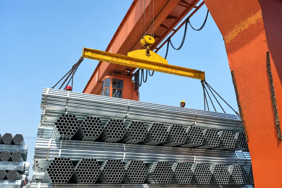Bundles of galvanised steel tube sections being lifted at a materials yard