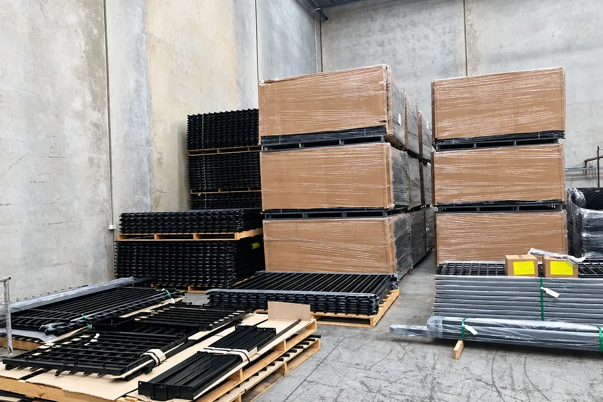 Different fence materials and components stored in separate stacks at a yard