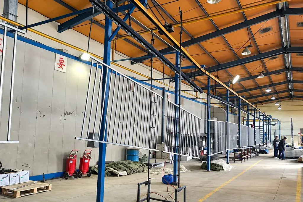 Steel fence components suspended along an industrial powder coating line