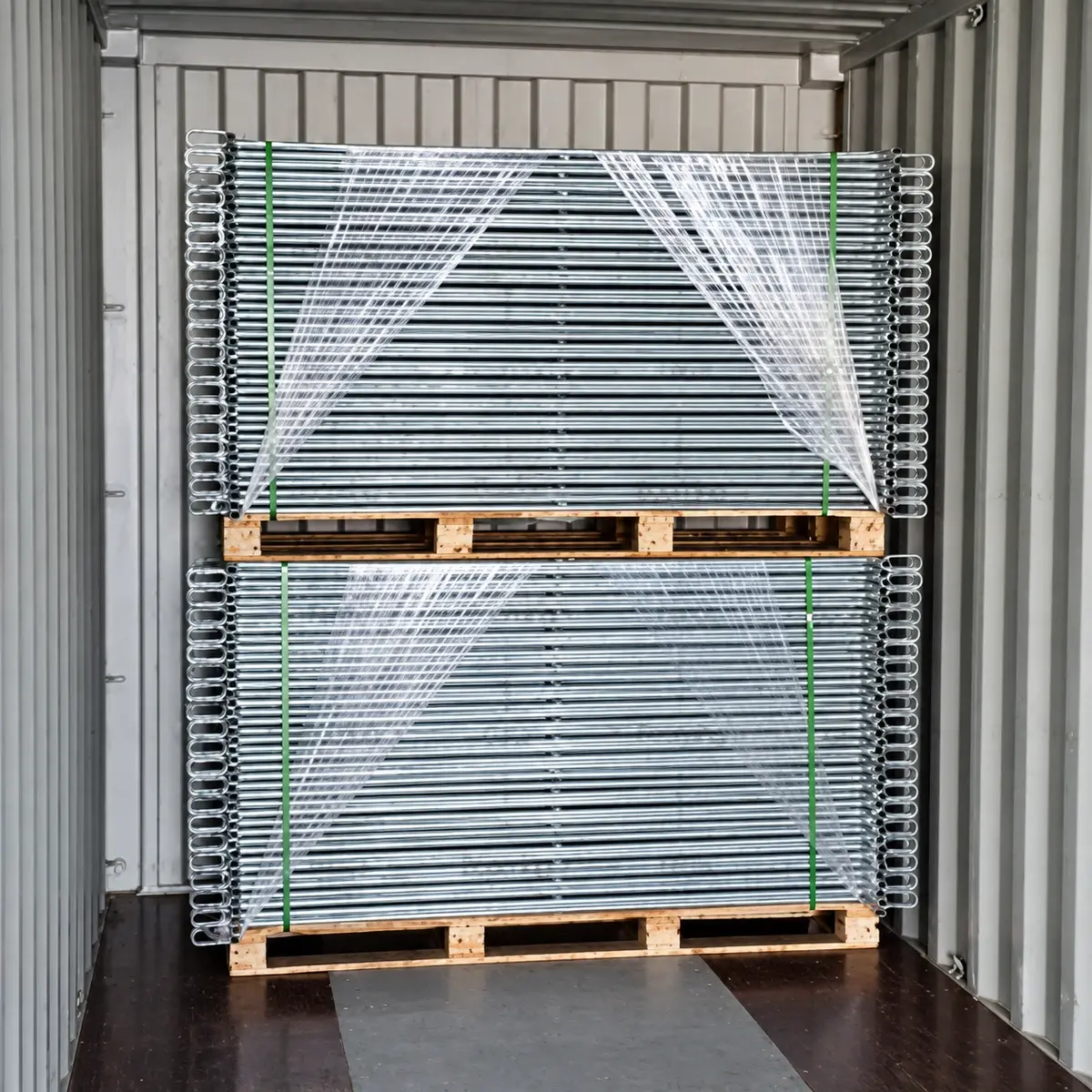 Packed metal fence sections framed within a container doorway