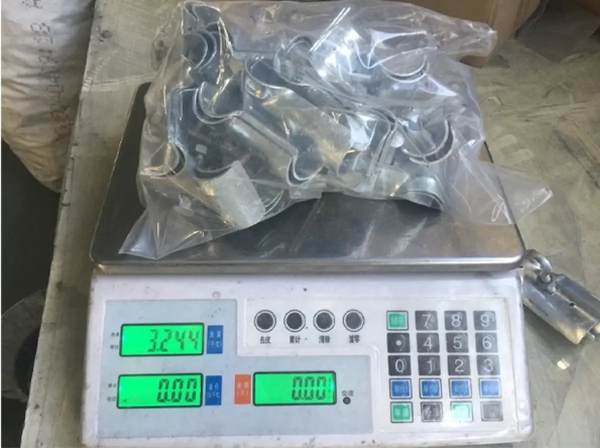 Bagged metal fence fittings placed on an electronic scale