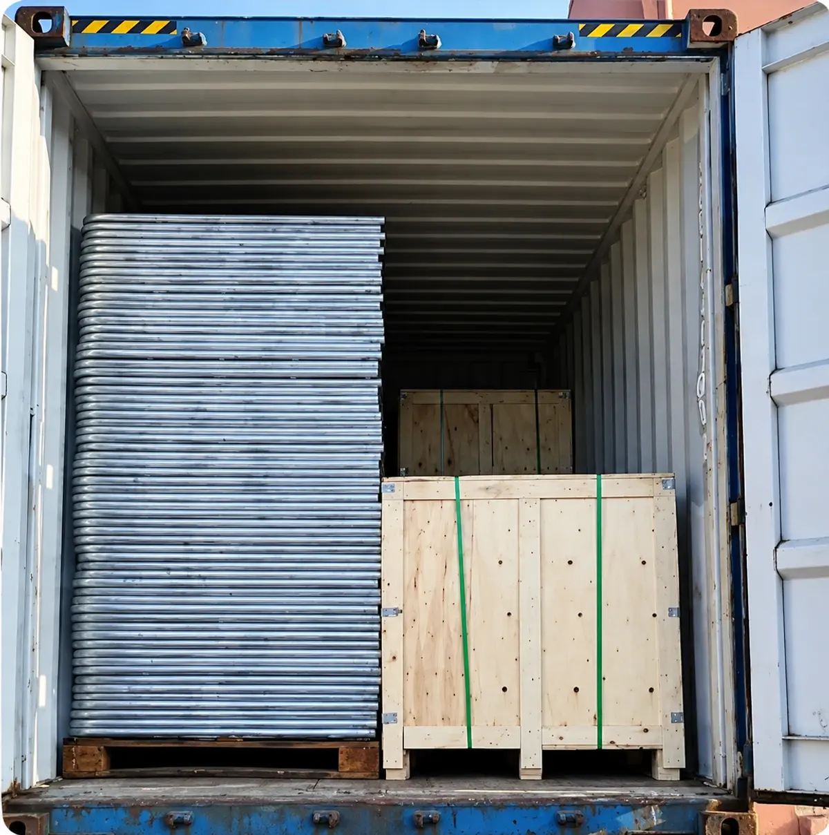 Wooden crate beside bundled metal fence components inside a container