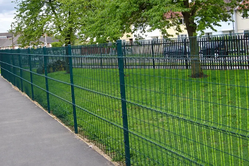 Installed welded mesh panels and posts along a path