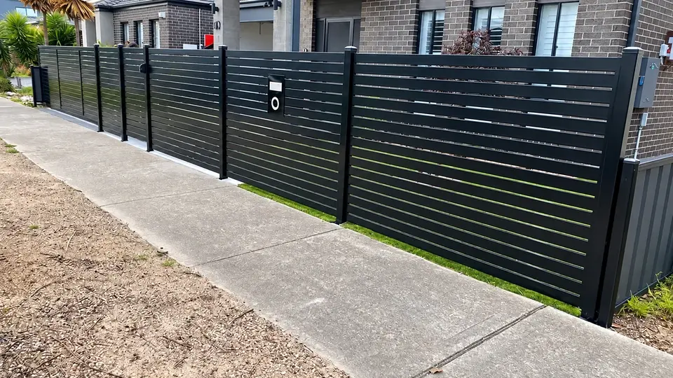 Horizontal aluminum slat fence across a residential frontage