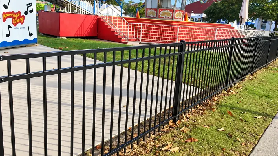 Metal railing separating a path from an amusement area