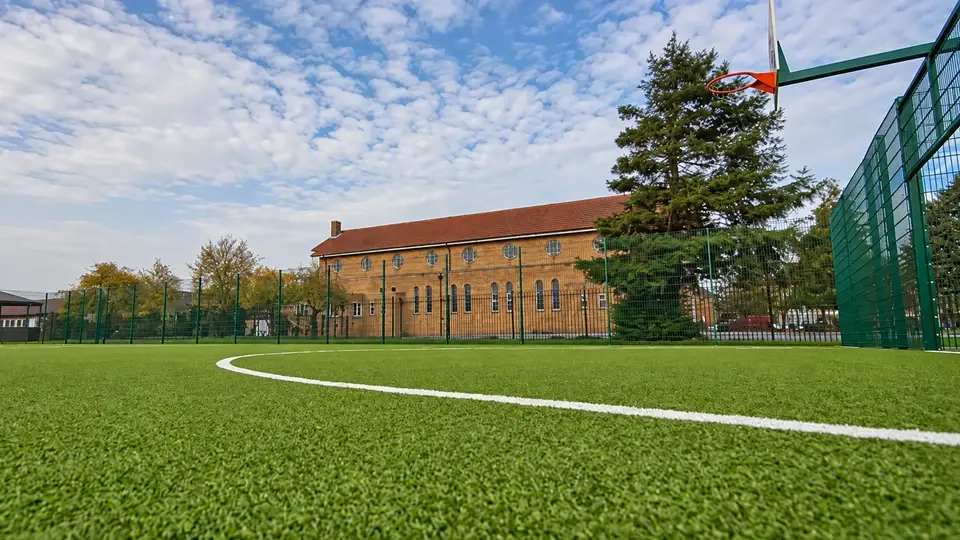 Mesh fencing around an artificial turf sports area