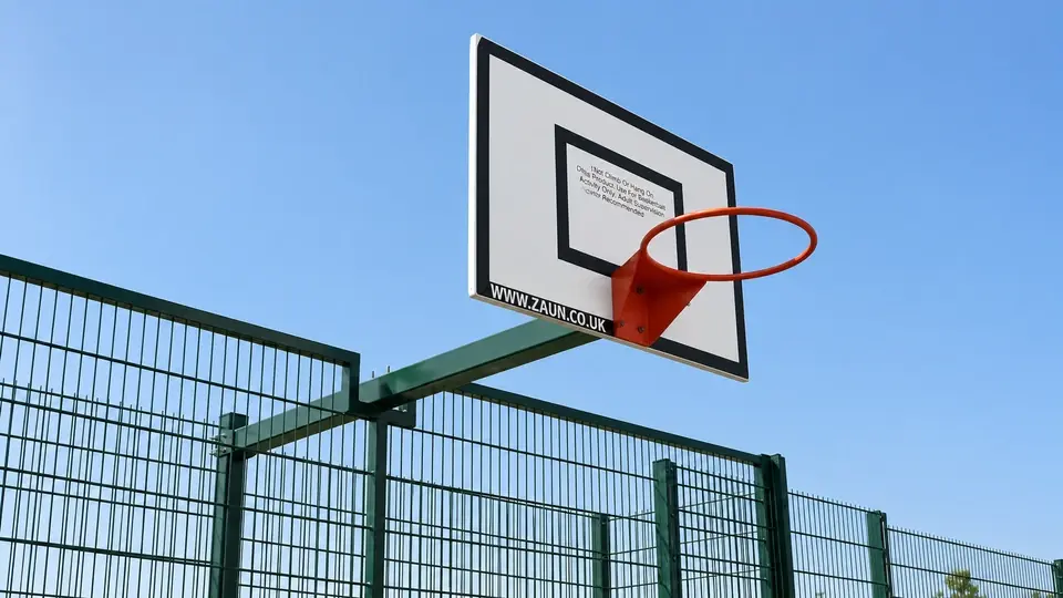 Basketball backboard mounted beside sports mesh fencing