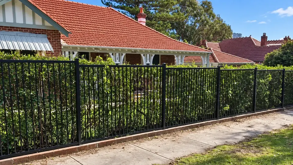 Black metal boundary fence in front of a house