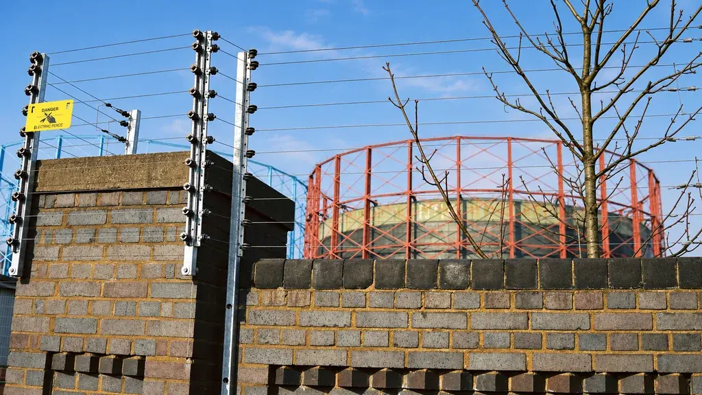 Extension posts carrying wires above a boundary wall