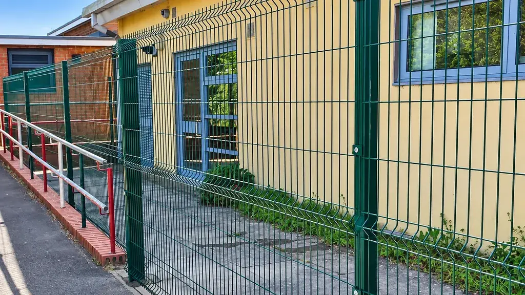 Welded mesh panels and a gate beside a building