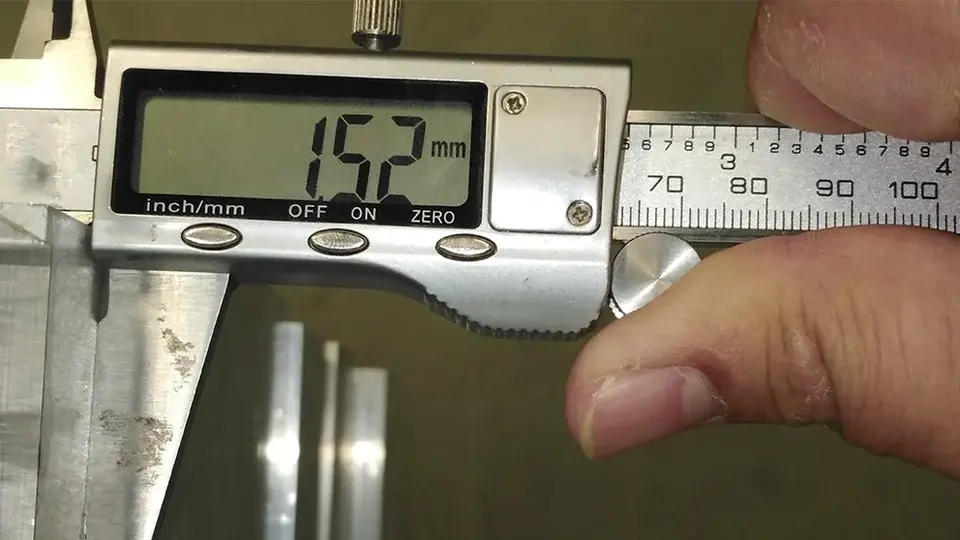 Digital caliper checking the thickness of a galvanized metal profile