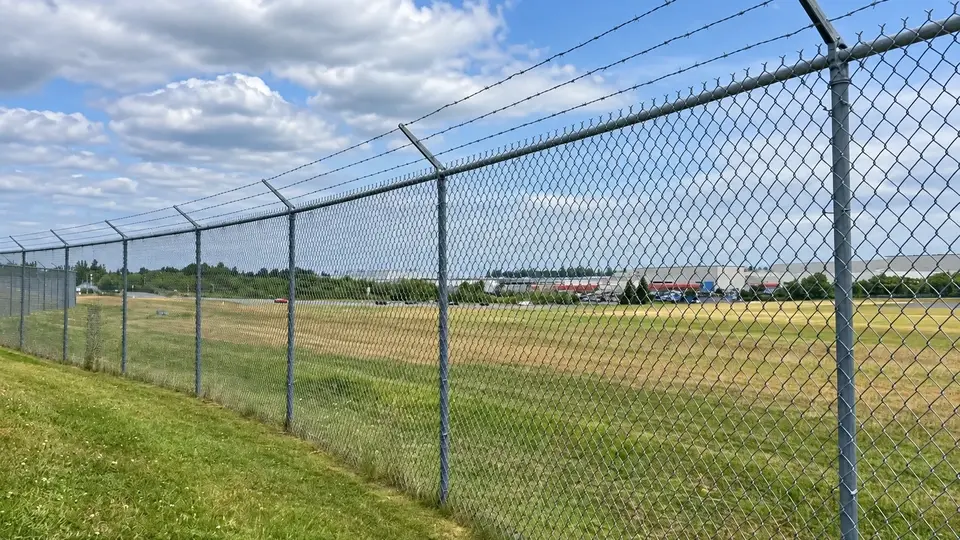 Chain link perimeter with angled barbed wire extensions