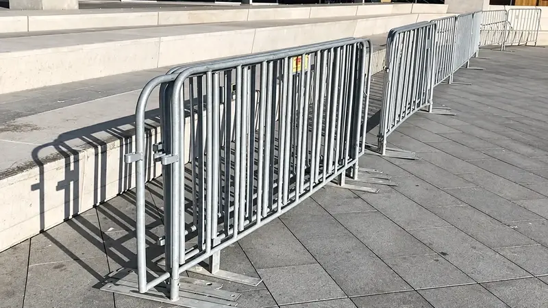 Rows of metal crowd barriers lining a city street