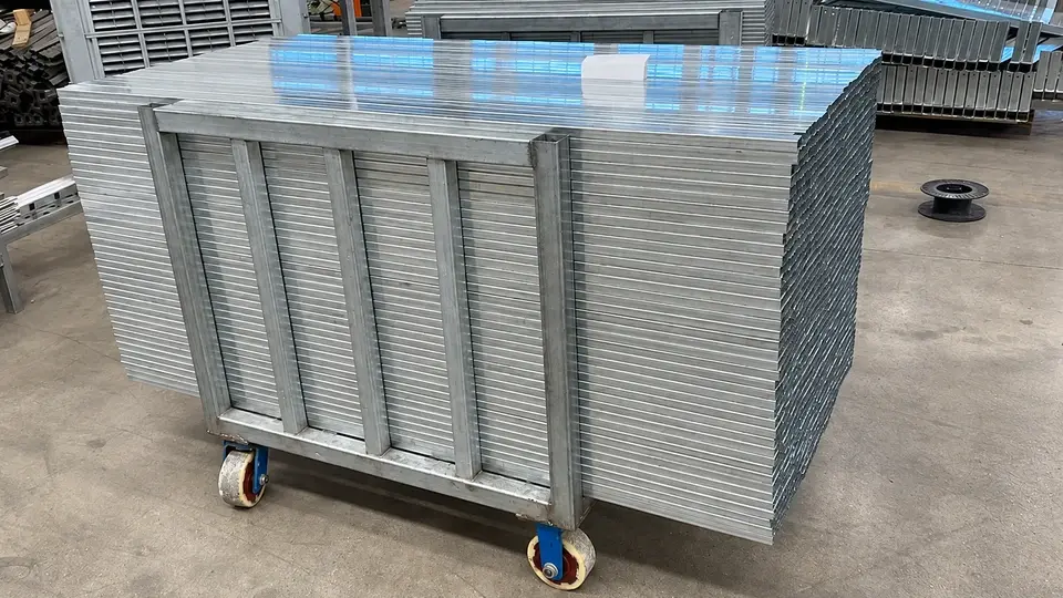 Galvanized mesh panels stacked on a workshop trolley
