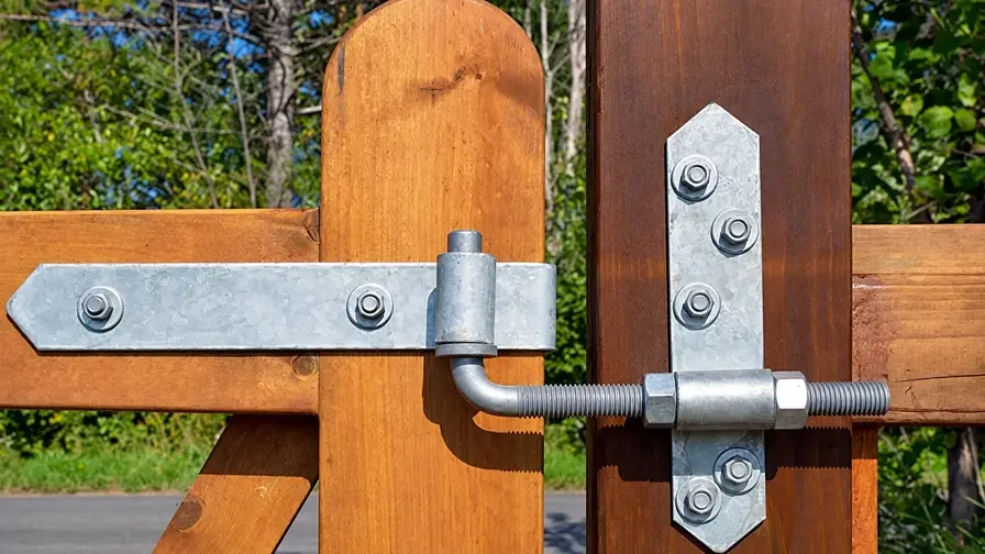 Adjustable galvanized hinge joining a timber gate and post