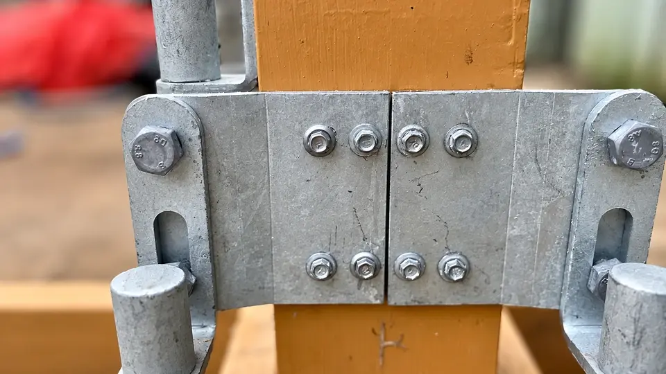 Galvanized gate hinge assembly bolted through a timber post