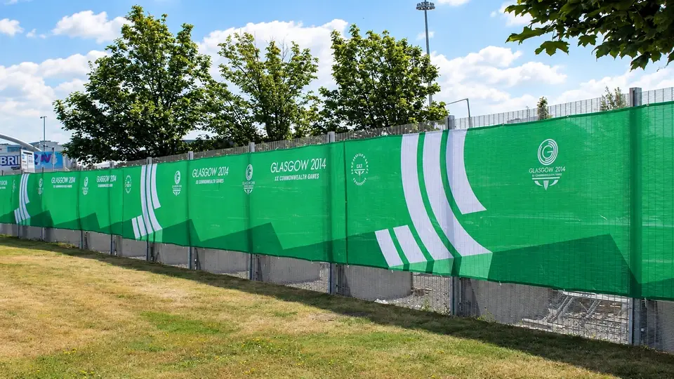 Temporary mesh perimeter with green screening at an event site