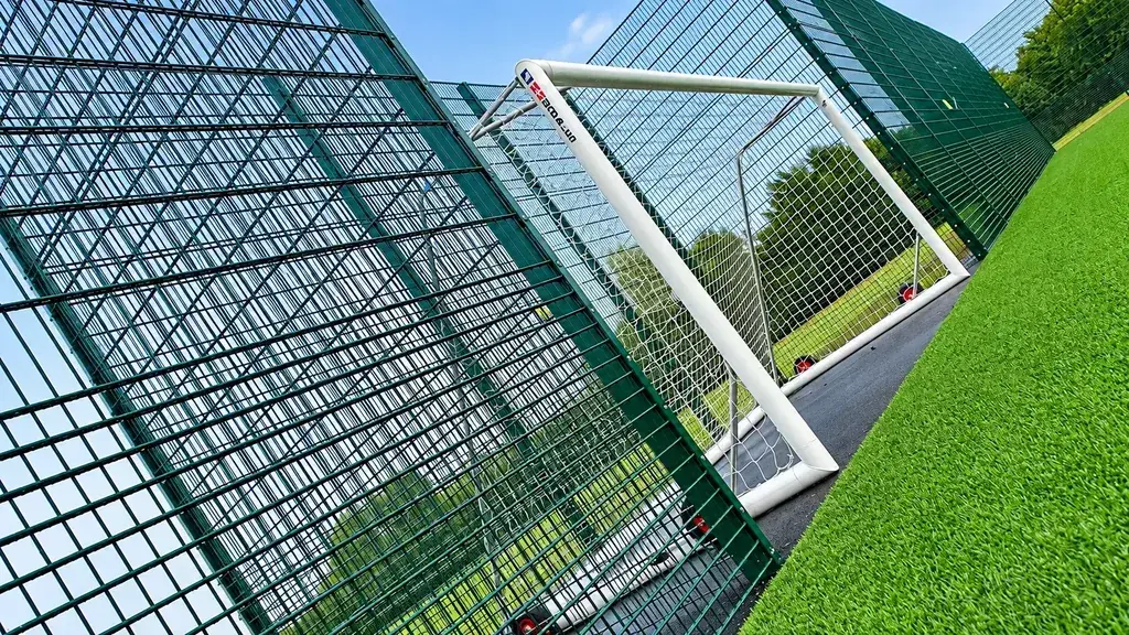 Tall mesh enclosure beside an industrial building