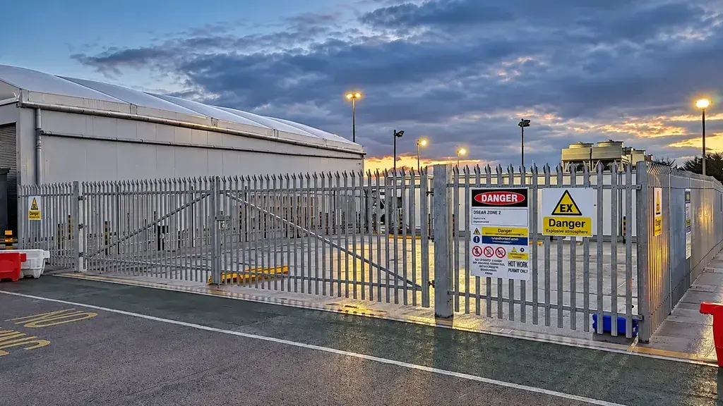 Galvanized palisade enclosure around industrial equipment