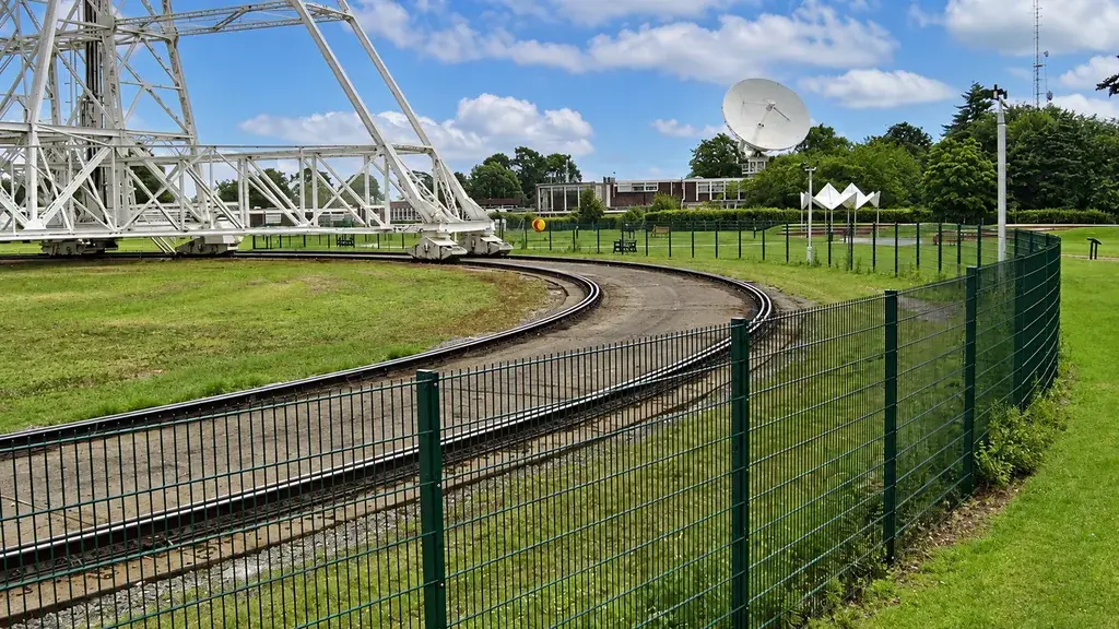 Mesh fencing separating a path from large industrial equipment