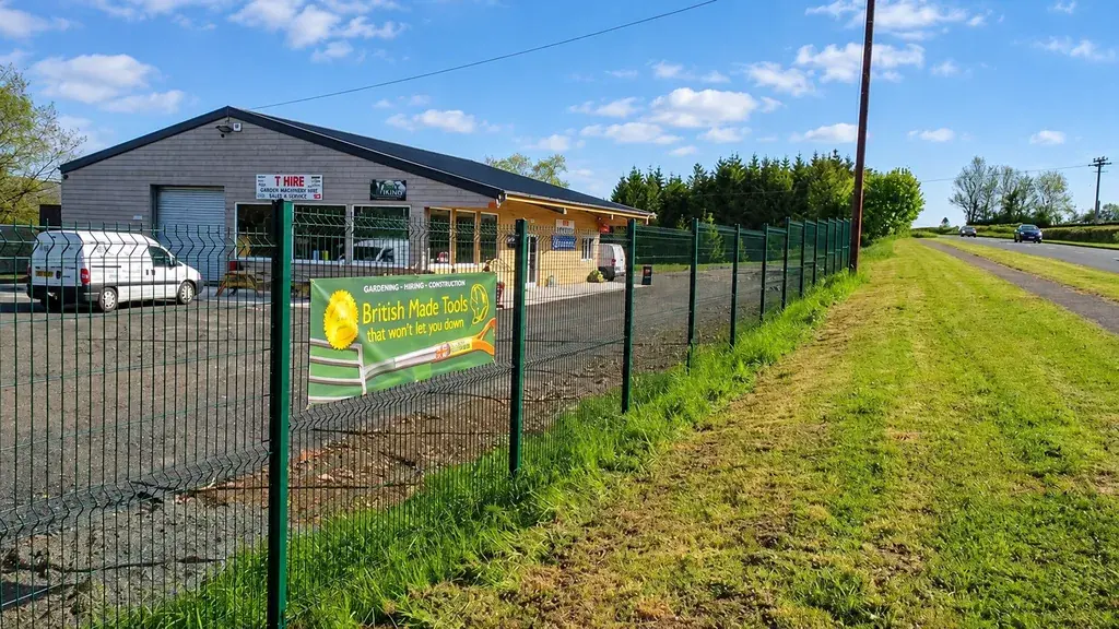 Mesh fencing following a grassy sloping boundary
