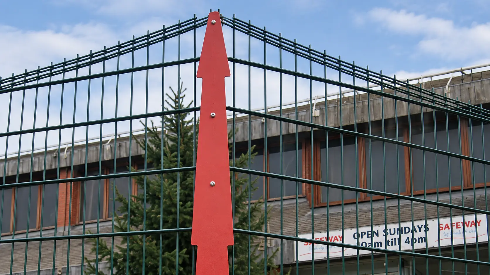 Continuous clamp bar securing mesh panels to a post