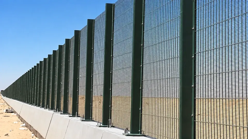 Security mesh panels mounted above a continuous concrete base