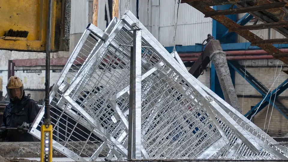 Galvanized mesh panels suspended above a treatment bath