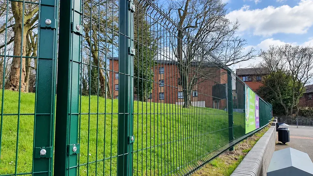 Mesh panels and upright posts along a retaining wall