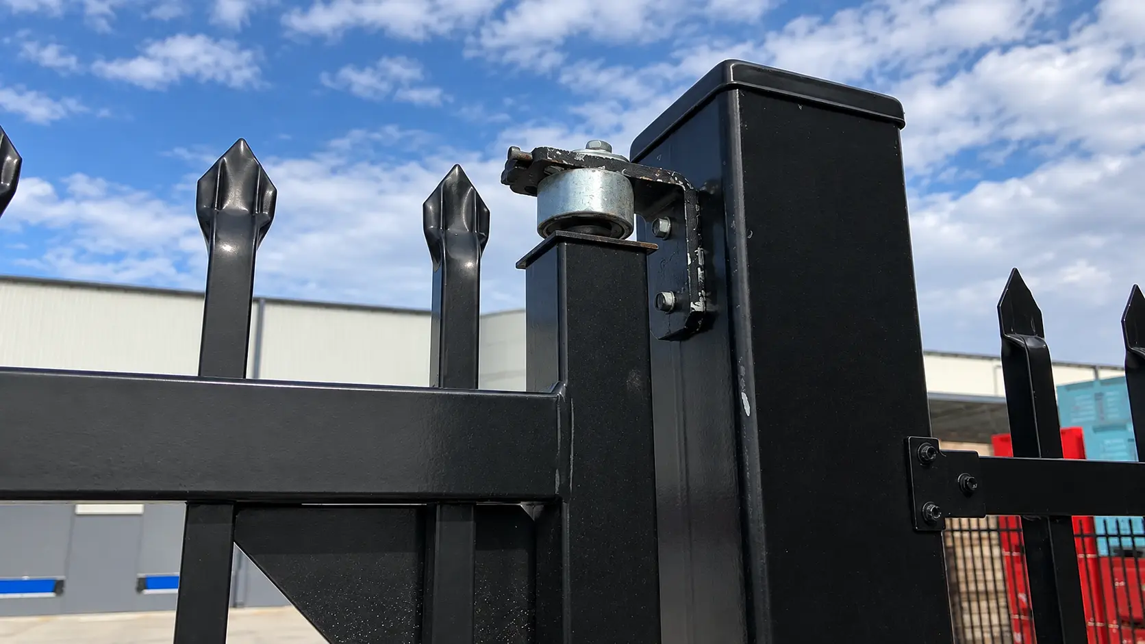 Metal gate hinge connected to a dark square post