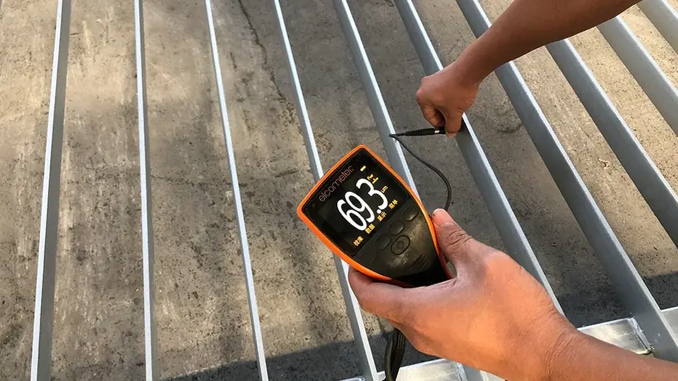 Coating gauge measuring the surface of a metal slat panel