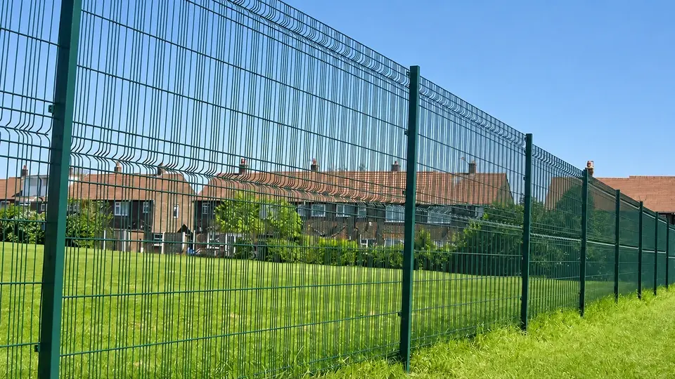 Tall profiled mesh panels beside a grassy boundary