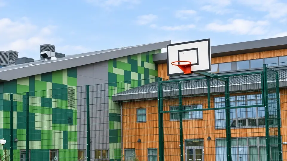 Recessed basketball goal integrated into a school mesh enclosure