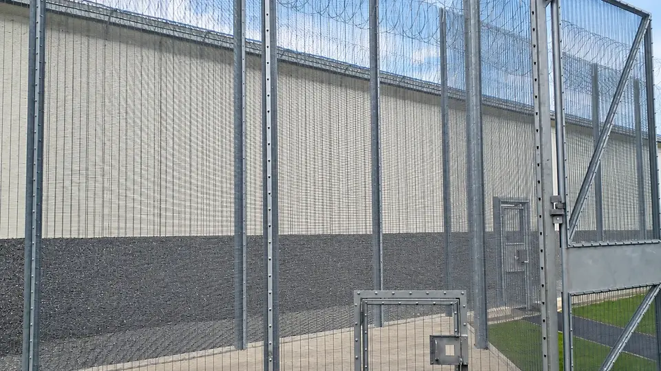 Security gate posts and mesh connections at a secure entrance