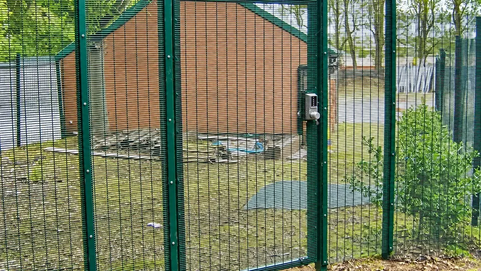 Small mesh pedestrian gate matching a security fence