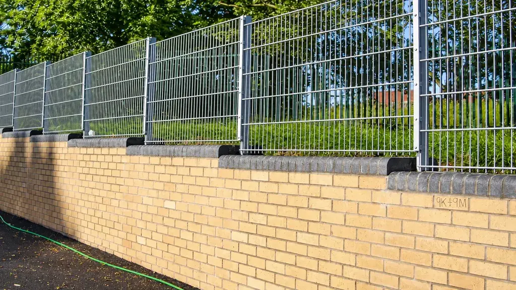 Stepped welded mesh panels installed above a brick wall