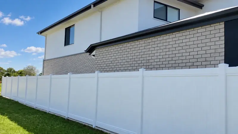 White vinyl privacy fence beside a modern house
