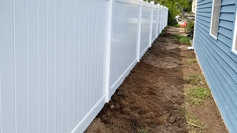 White vinyl privacy panels along the side of a house