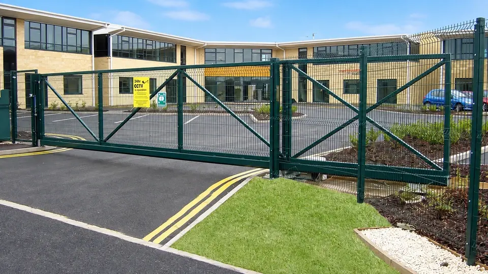 Wide mesh vehicle gate across a paved driveway