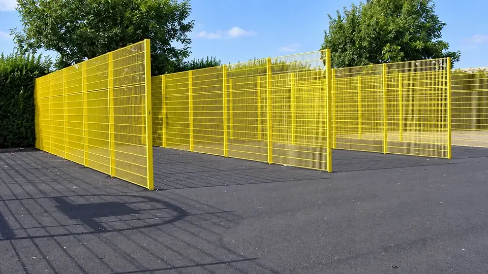Yellow mesh partitions dividing an outdoor practice area