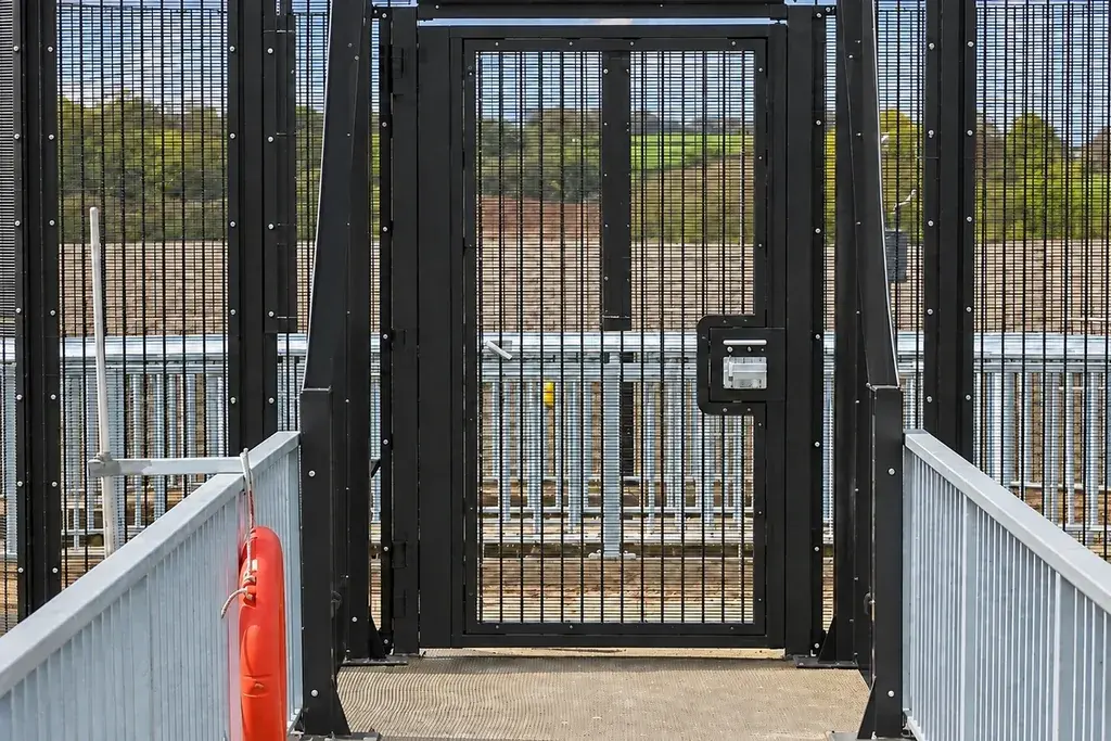 Approach view of a close-mesh security pedestrian gate