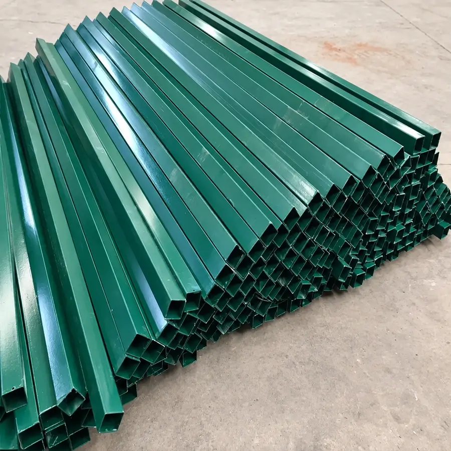 Green hollow steel fence posts stacked together