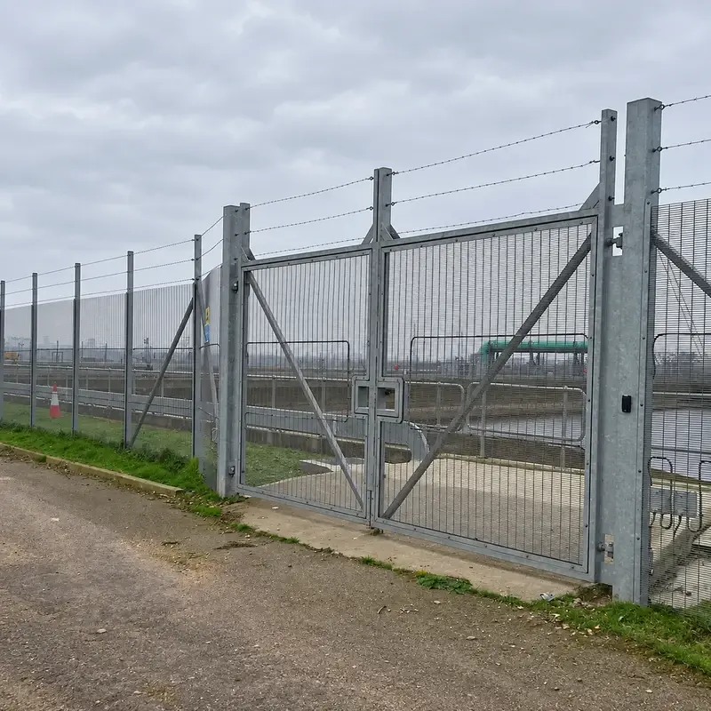 Galvanised close-mesh vehicle gate beside matching fence