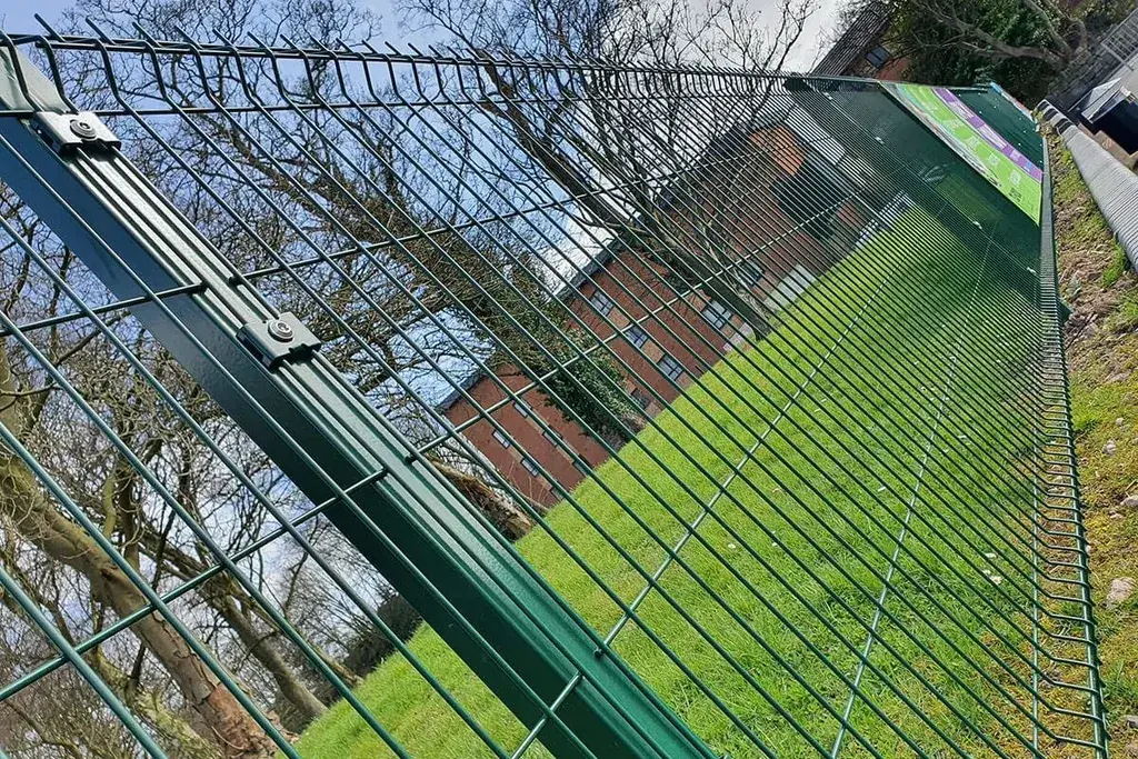 Green V-profile mesh panel held against a channel post with clips